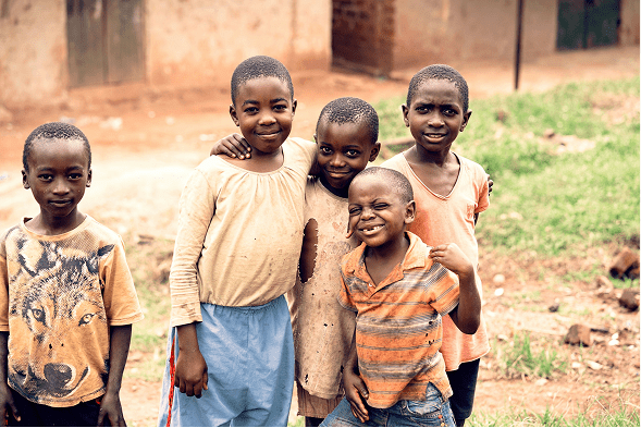 four kids smiling while standing