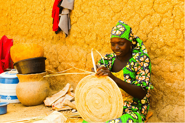 woman sitting while weaving