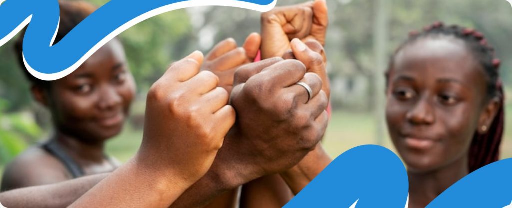 Close-up of diverse hands coming together in the center, symbolizing community unity and resilience amidst crisis Africa 2026.