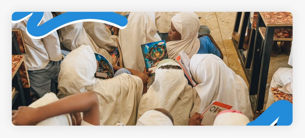 A large group of young kids sitting tightly on the floor due to a severe lack of space, demonstrating the urgent crisis of crowded classrooms in rural schools.