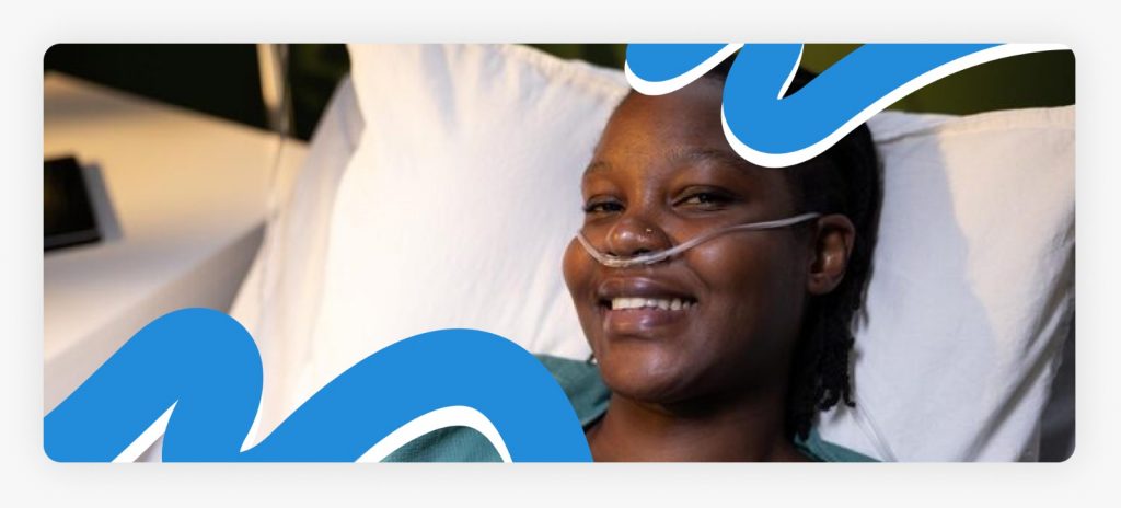 A bedridden lady smiling from her sick bed after receiving medical care, illustrating the impact of providing support for bedridden women in Africa.