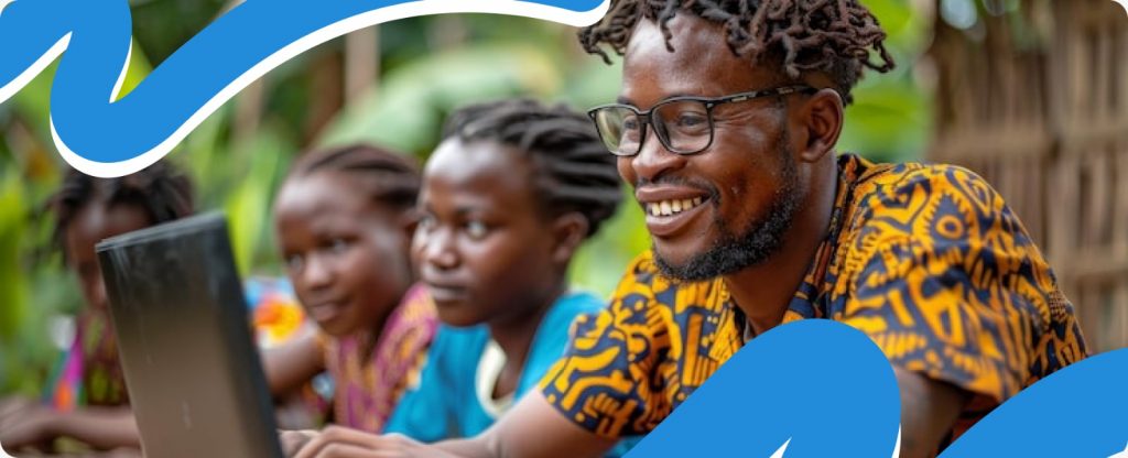 A smiling man sitting happily while using a laptop, showing the positive outcomes of digital literacy and NGO digital transformation 2026.