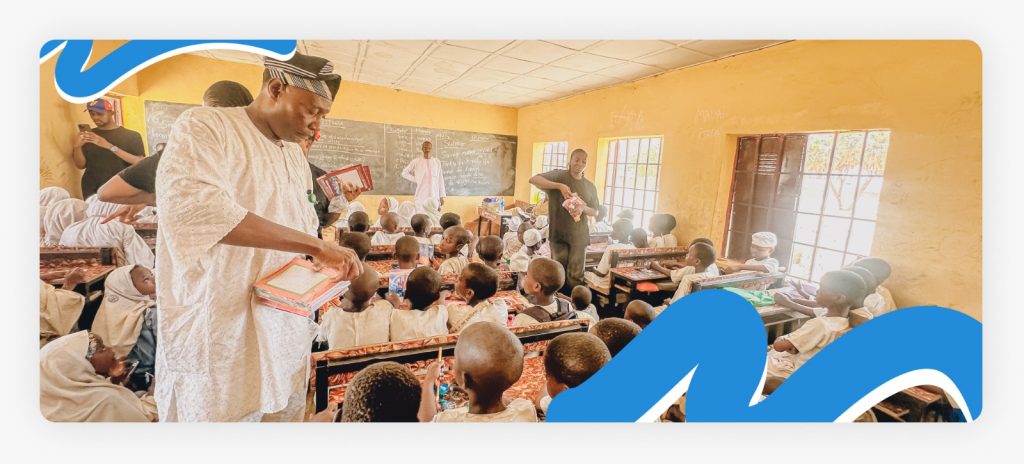 Primary school students, their teacher, and Better Life NGO staff members standing together inside the room, celebrating a major improvement in study classes for african suffering children.