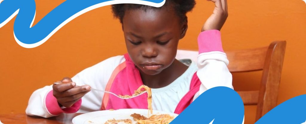 A close-up of a child eating life-saving nutritional paste, showing the direct impact of donor support for malnourished children in Africa.